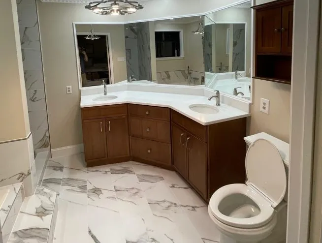 Bathroom renovation in Lehigh Valley, Pennsylvania, featuring new quartz flooring, double sink vanity, new shower, and toilet.